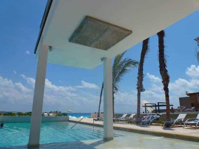 A large rain shower set over the Barefoot Pool at Secrets The Vine in Cancun. 