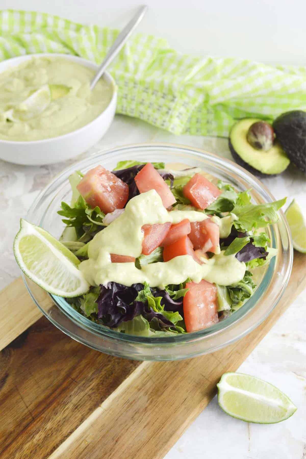 A bowl of salad topped with avocado lime ranch dressing.