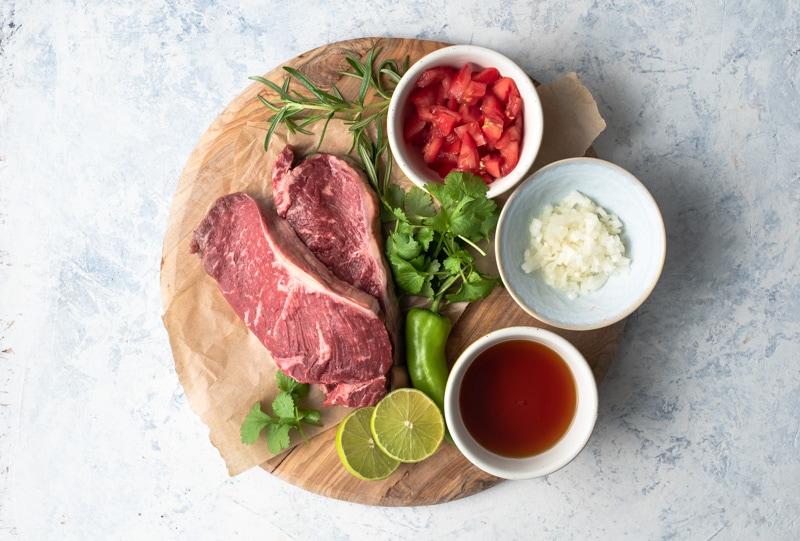 Ingredients for making grilled steak marinade and a fresh salsa on a wooden board. 