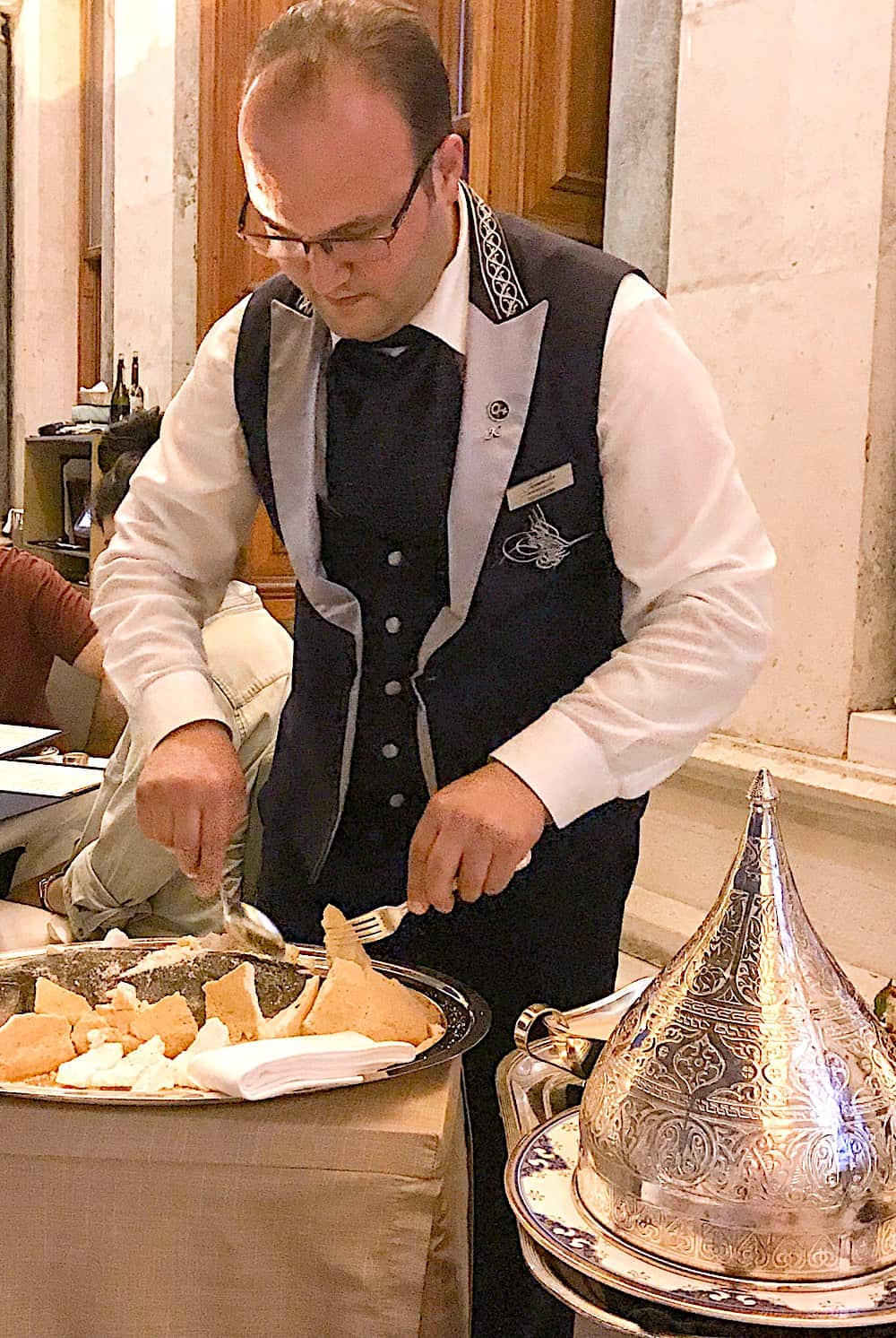 Server cutting open the sea bass in rock salt dough.