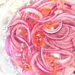 A glass bowl of Siboya Tempera marinated onion salad from Aruba.