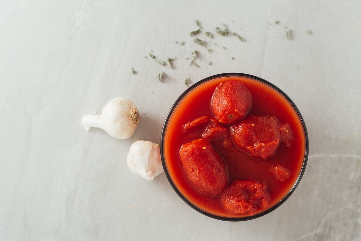 San Marzano tomatoes in a bowl with garlic and oregano.
