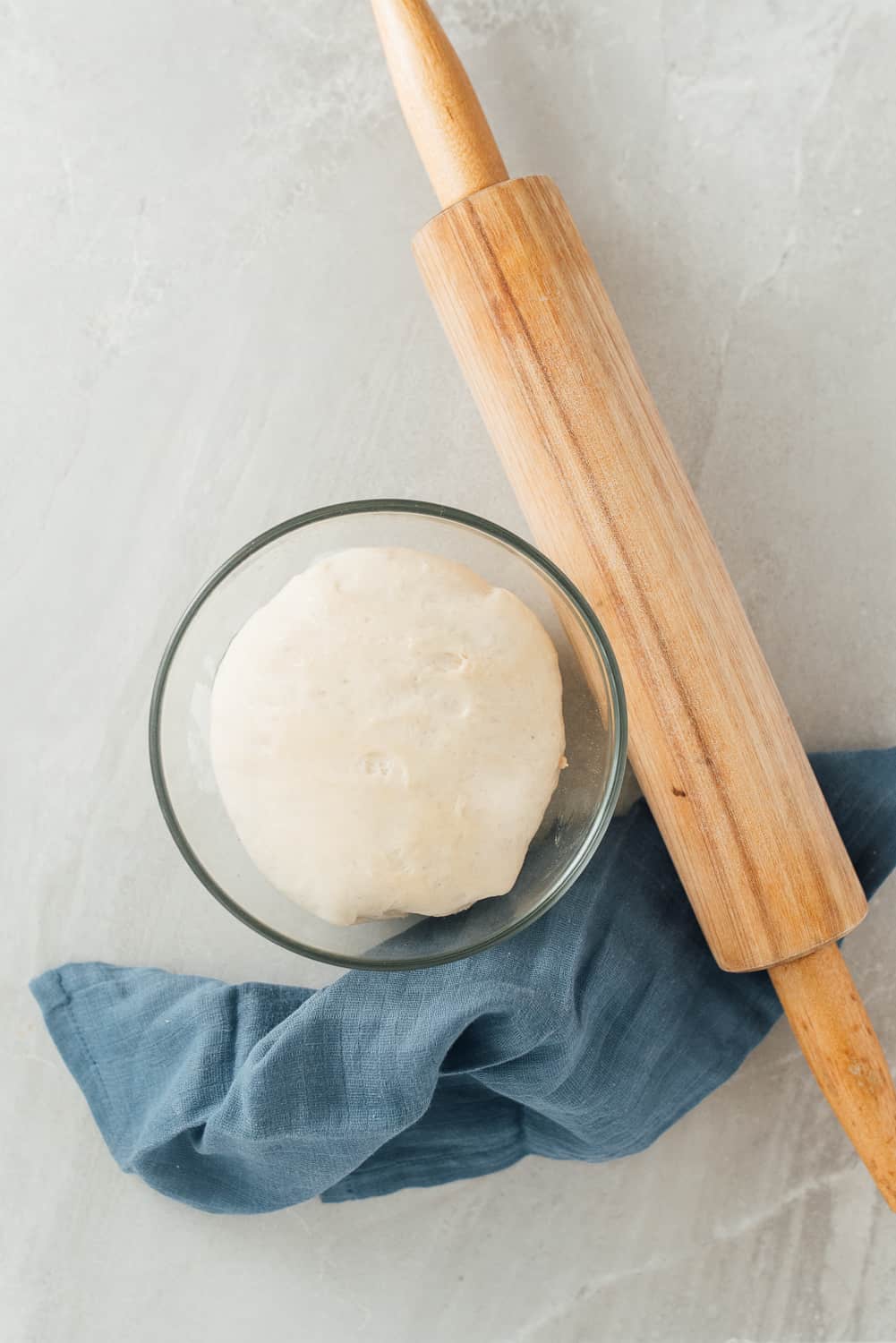 Pizza dough with rolling pin.