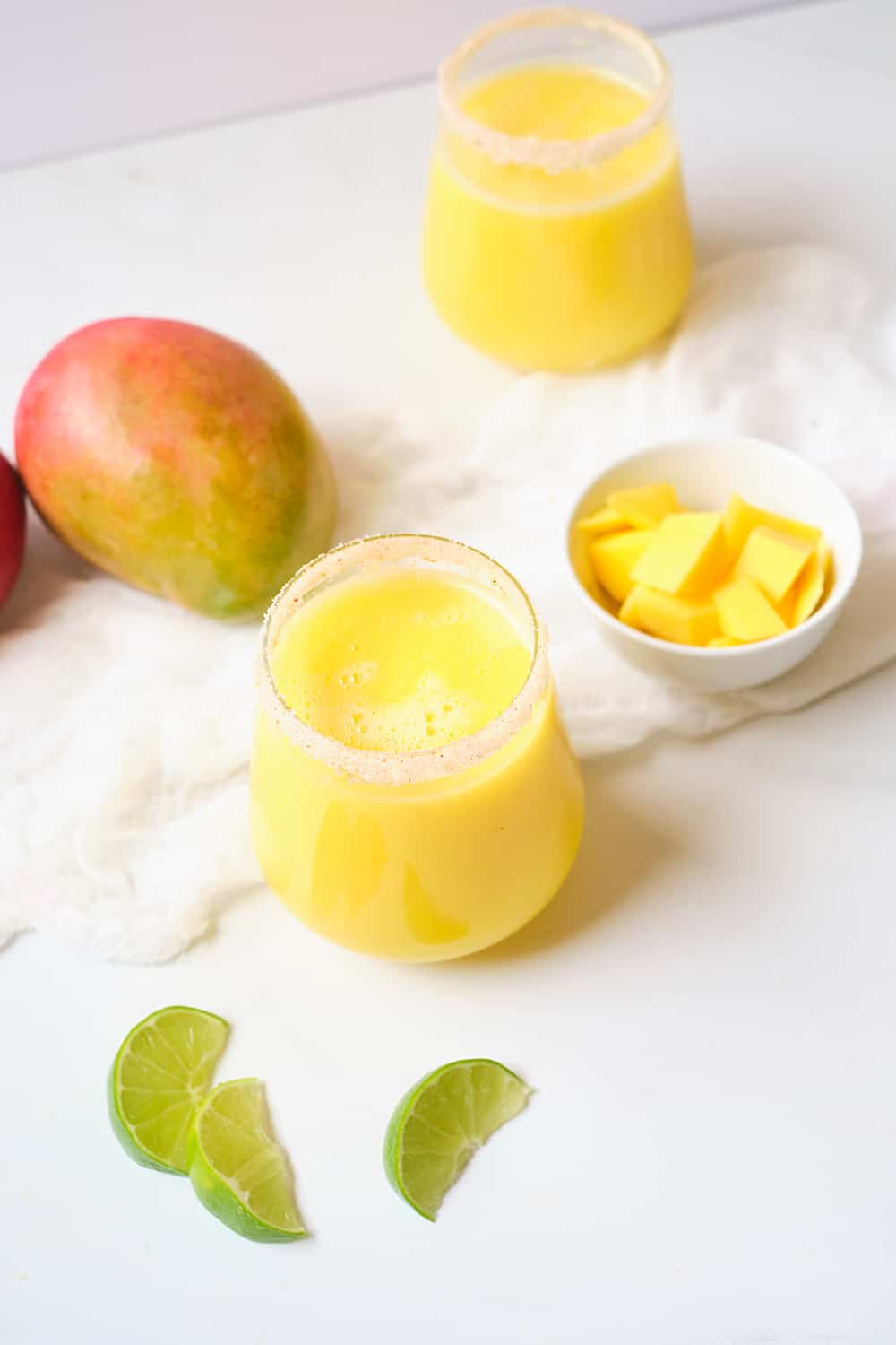 Sparkling mango drink with a fresh mango in background.