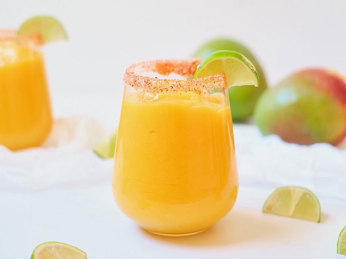 Sparkling mango cocktail on a white table.