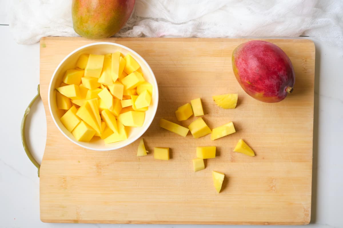 Chopped mango on a wooden board.