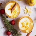 Two mugs of Ponche de frutas (hot fruit punch) with Christmas decorations.