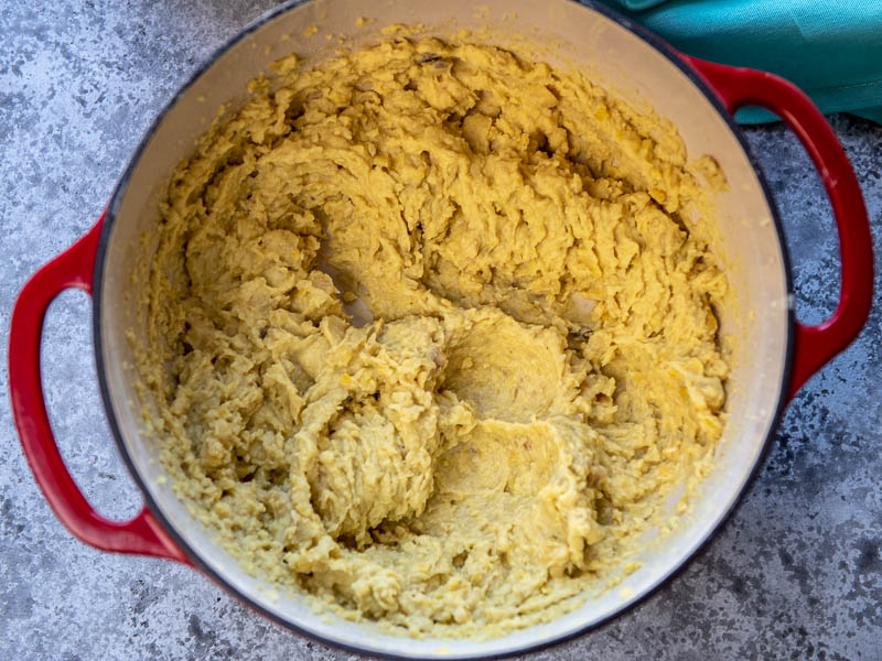 Mashed boiled fava beans in a red pot.
