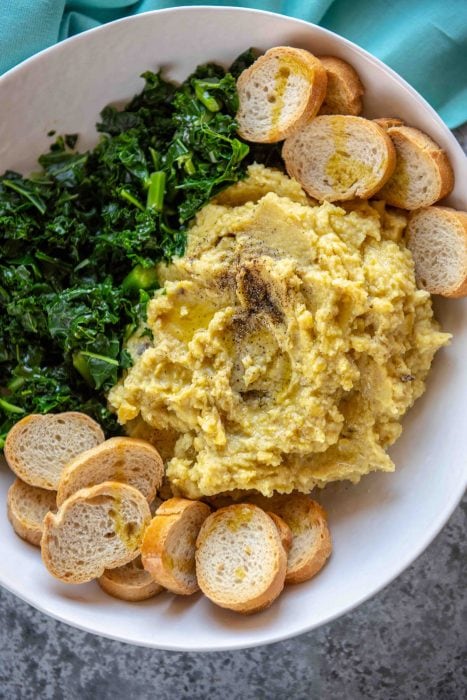 Italian Fava Bean Puree with greens on a white plate.