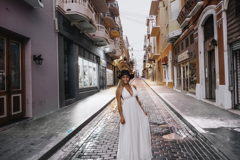 Woman in white dress on the cobblestone streets Old San Juan in Puerto Rico Itinerary.