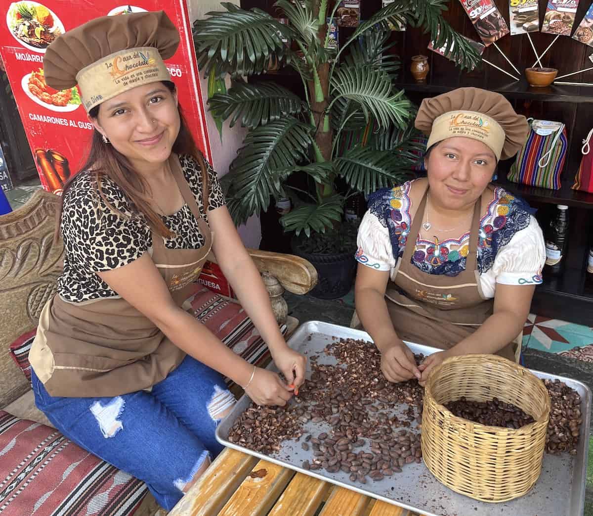 Two young women deomonstrating cacao sorting.