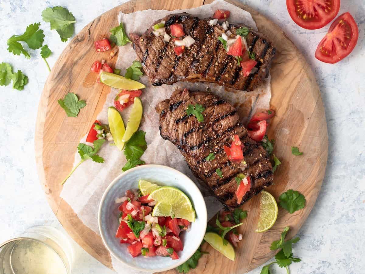 Grilled steak marinated in beer on a wooden board.  