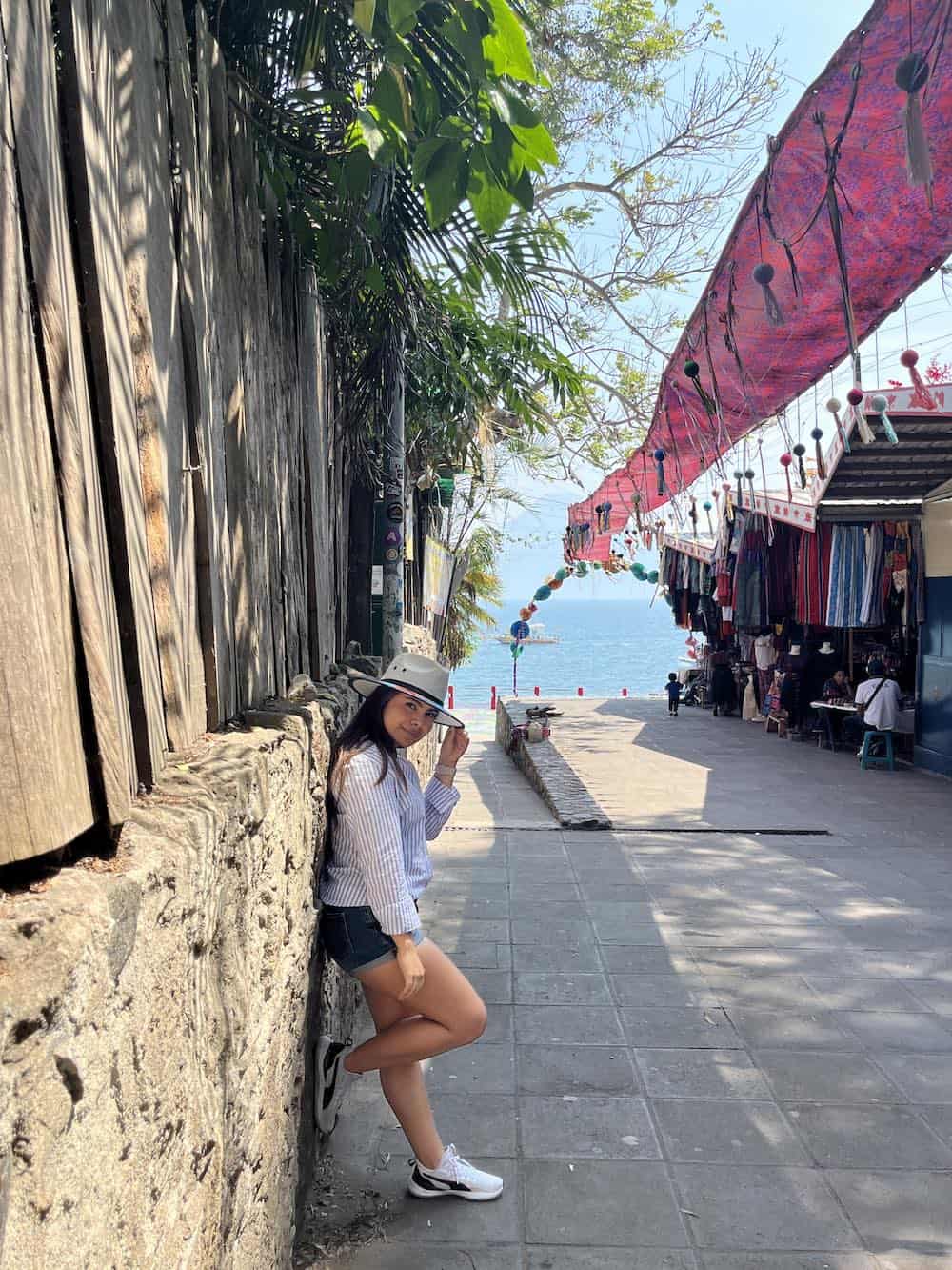 Young woman walking n Panajachel with view of Lake Atitlan. 