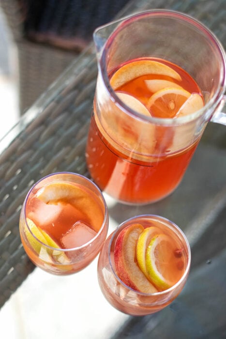 Pitcher of bourbon ginger punch on a wooden table.