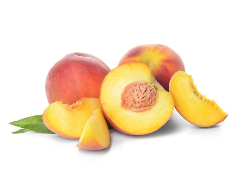 Whole and cut peaches on white background. 
