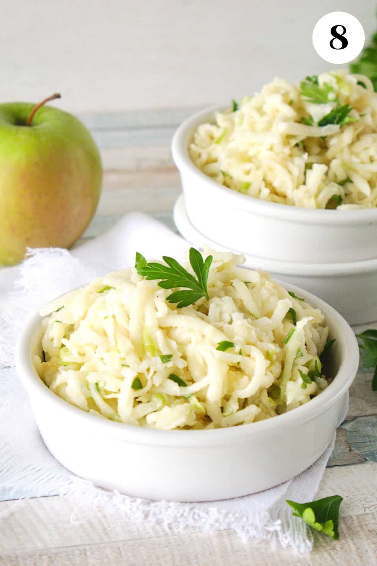 Bowl of jicama apple slaw garnished with parsley.