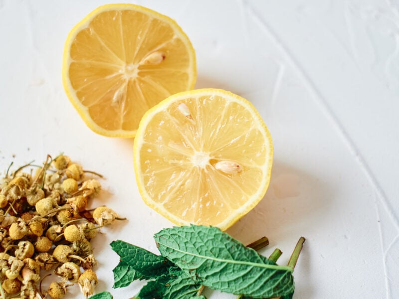 the ingredients to make chamomile tea - lemon, dried chamomile and mint