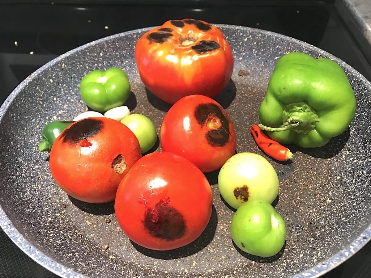 Pan-roasting tomatoes in a skillet for salsa.