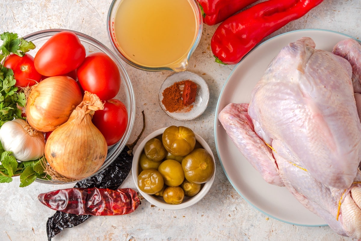 Ingredients for kak'ik turkey soup include turkey, tomato, tomatillos, broth, cobanero chile, tomato, onion, red peppers, achiote and tomatoes.