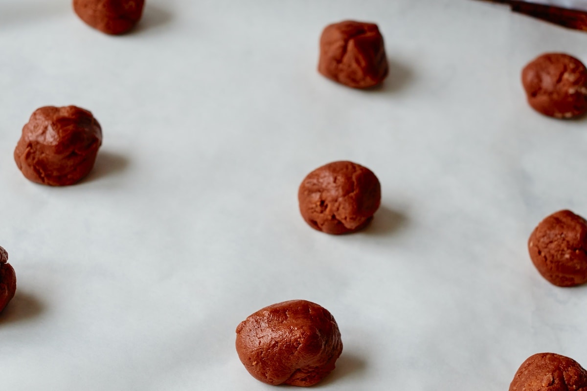 Rounded cookies on a baking pan.