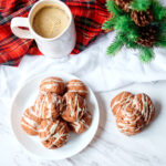 Iced chocolate eggnog cookies on a white plate.