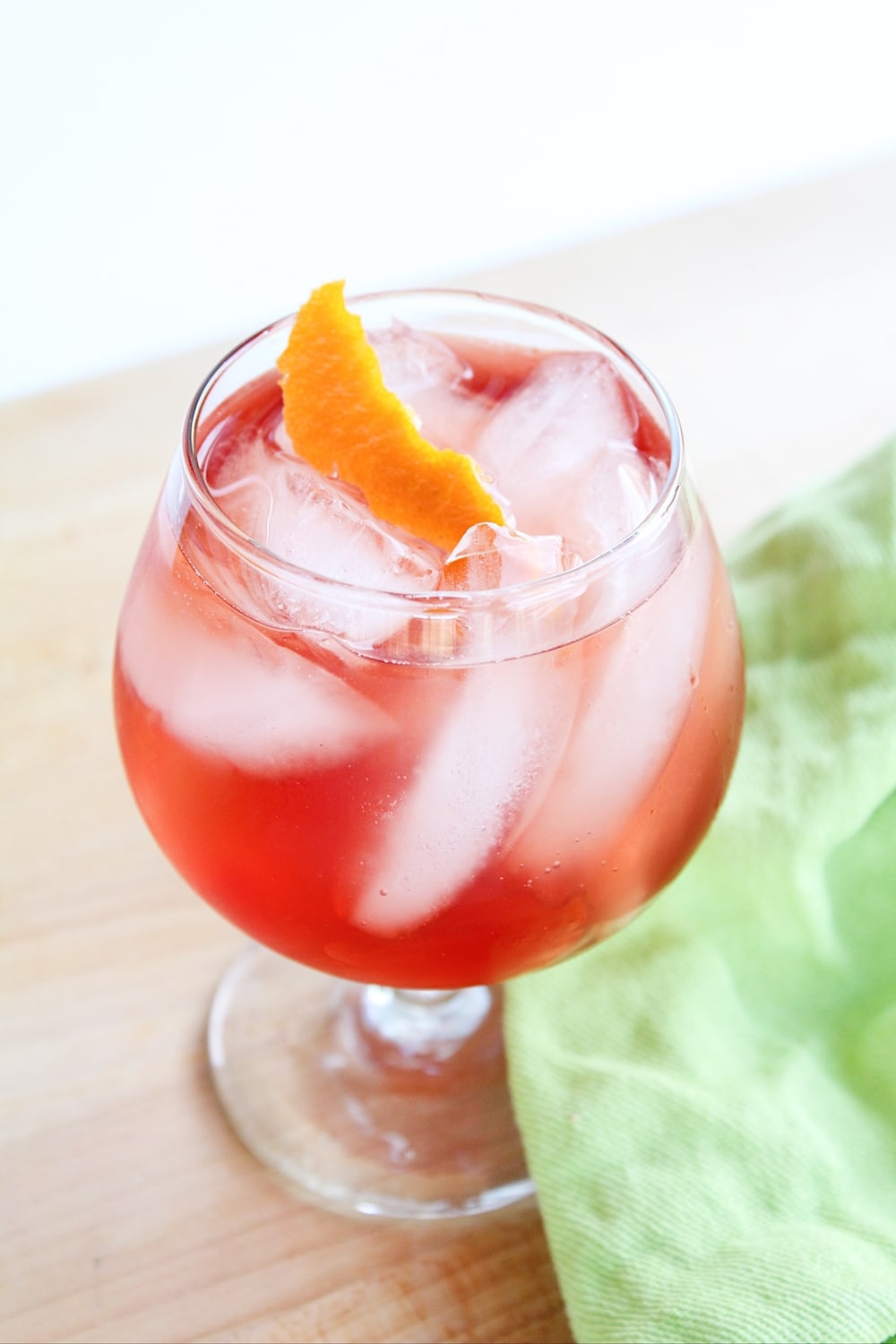 Portrait of a Campari Valentine's Day cocktail with a green napkin. 