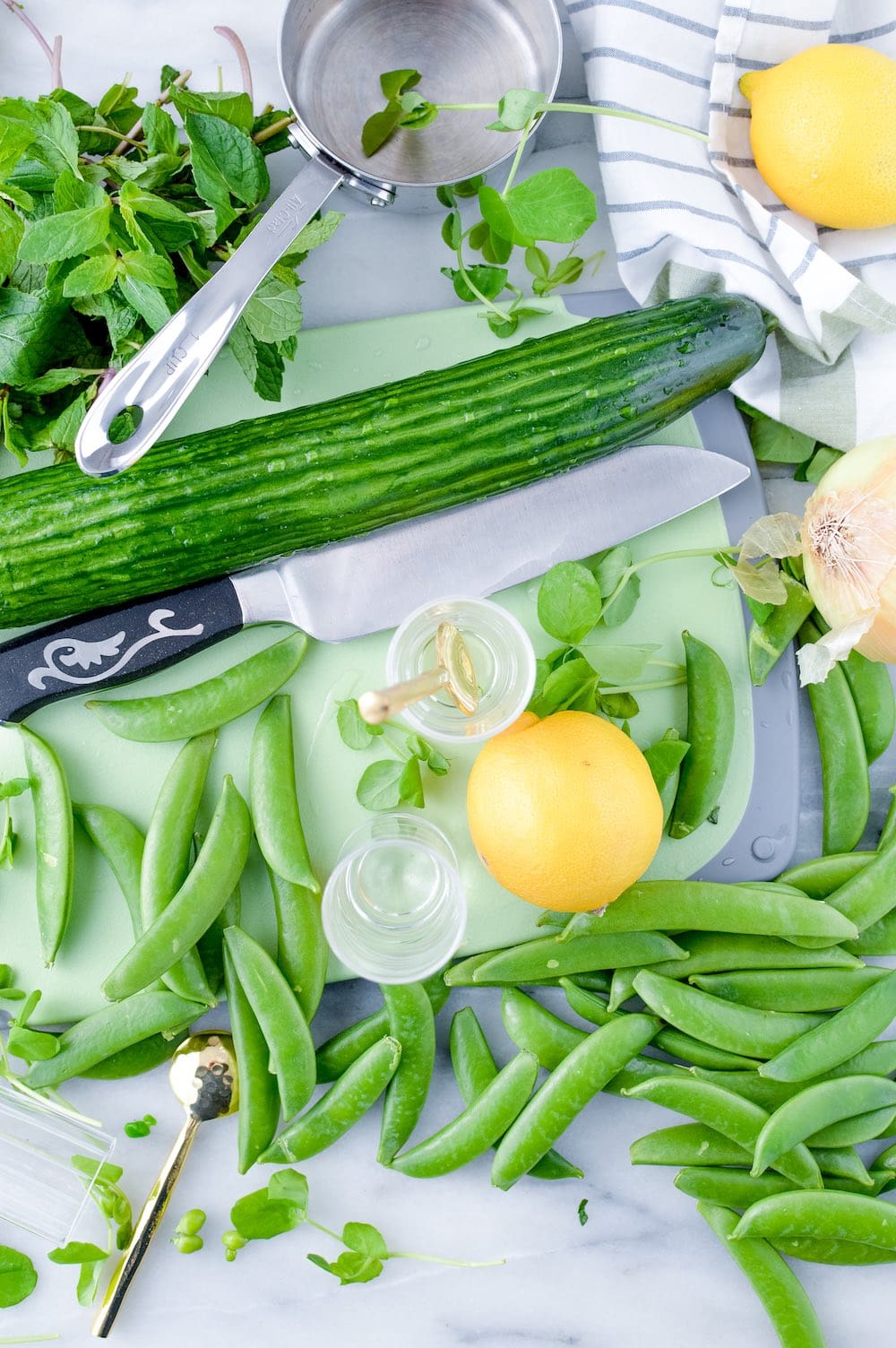 Ingredients for cold pea gazpacho include fresh peas, lemon, cucumber, mint, onion and olive oil.
