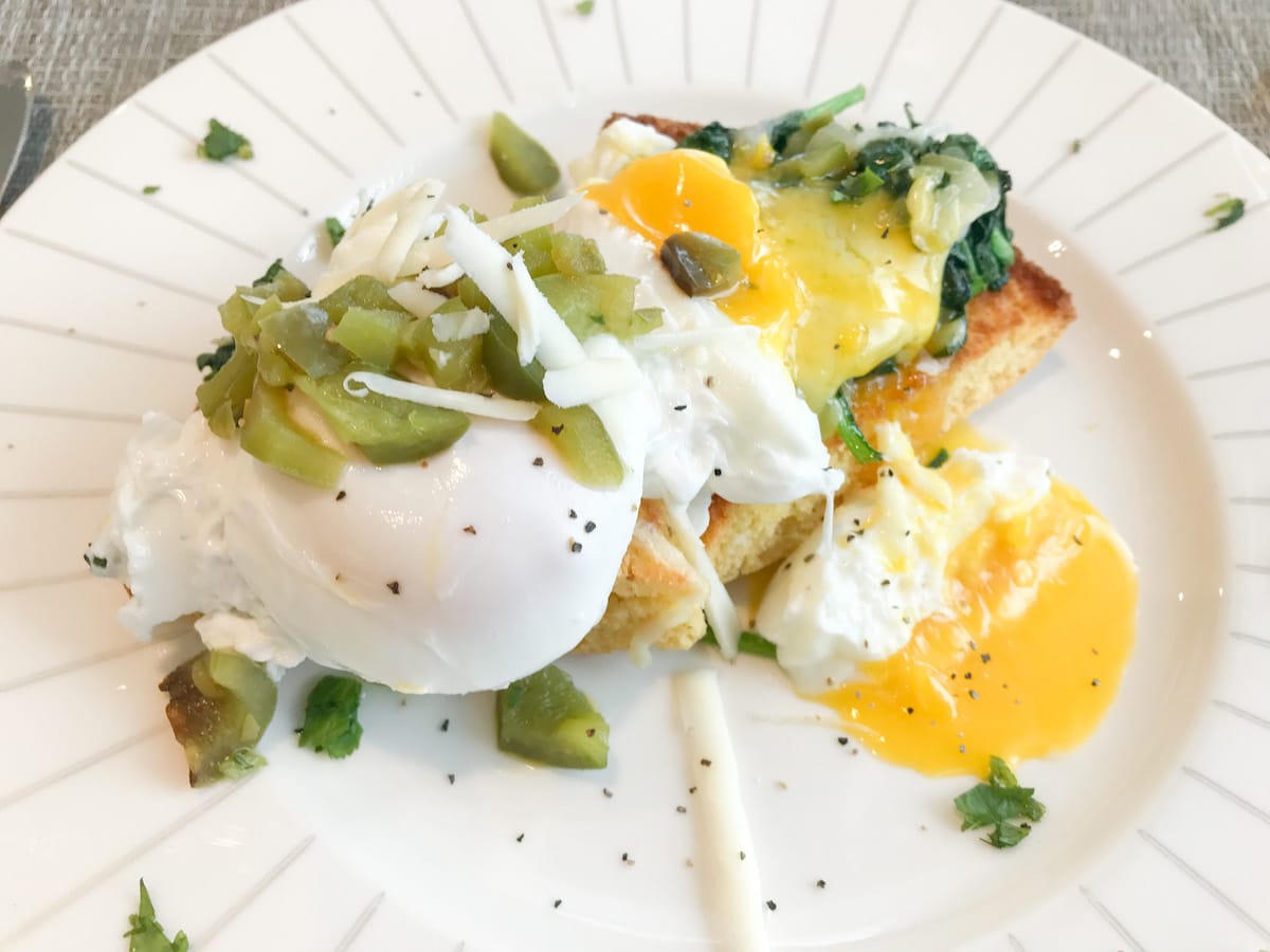 Cornbread topped with two eggs and green chiles. 