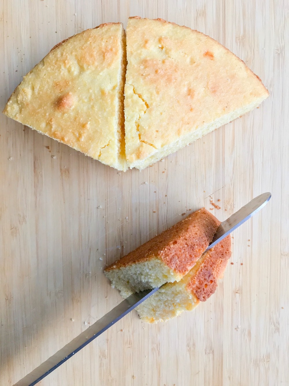 Knife slicing cornbread through the middle lengthwise.