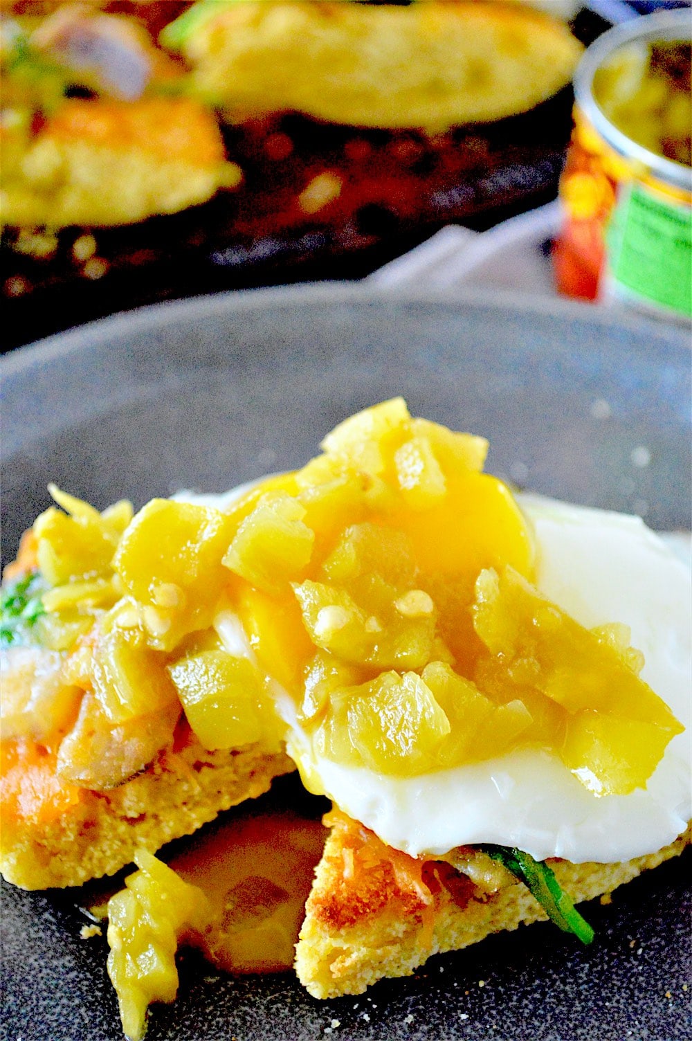 Breakfast egg topped with green chile on cornbread.