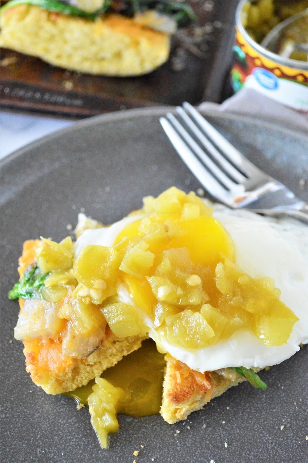 Green chile on top of fried egg with a fork.