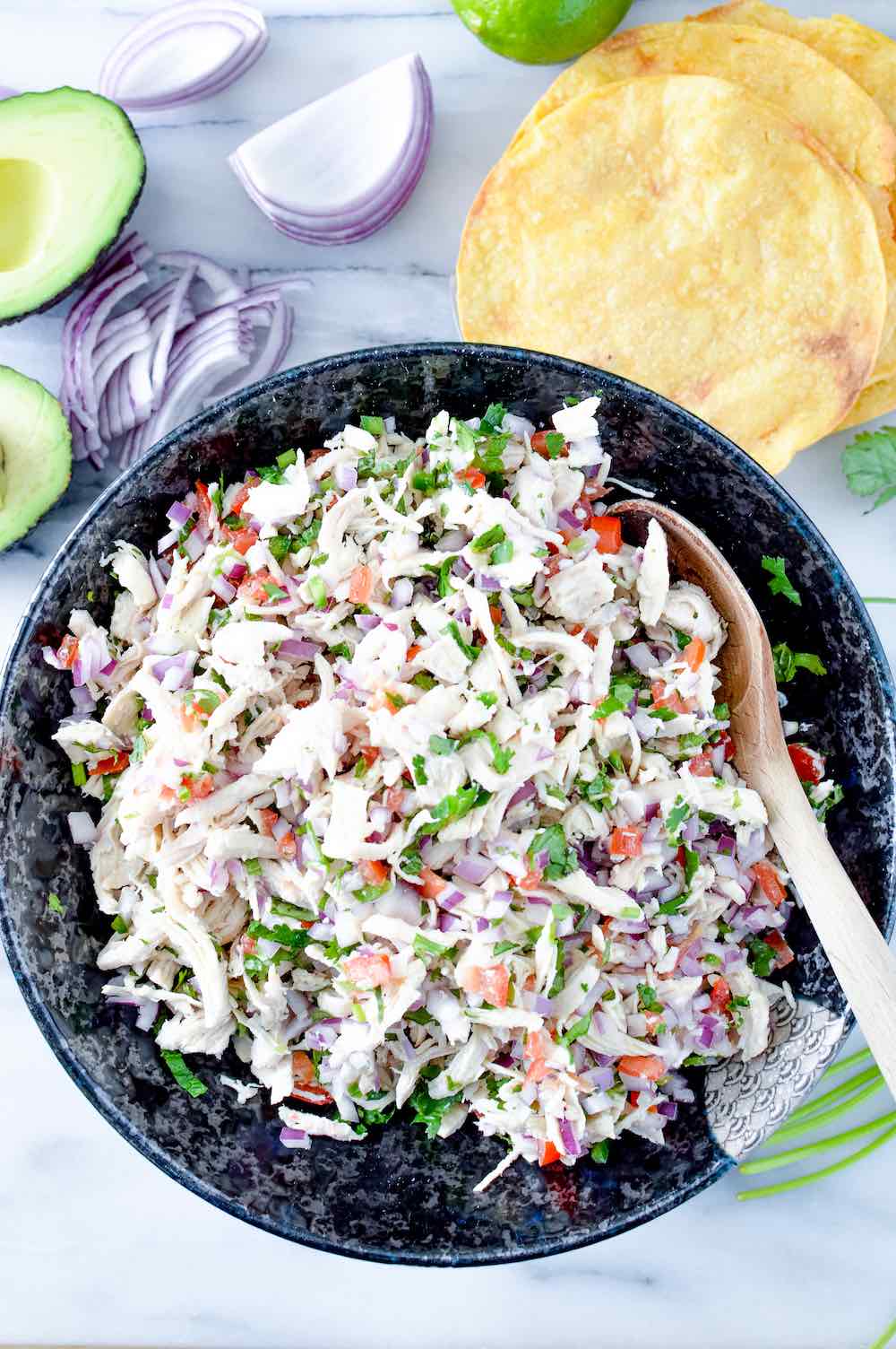 Close-up of vinaigrette and Mexican chicken salad in a bowl with a spoon. 