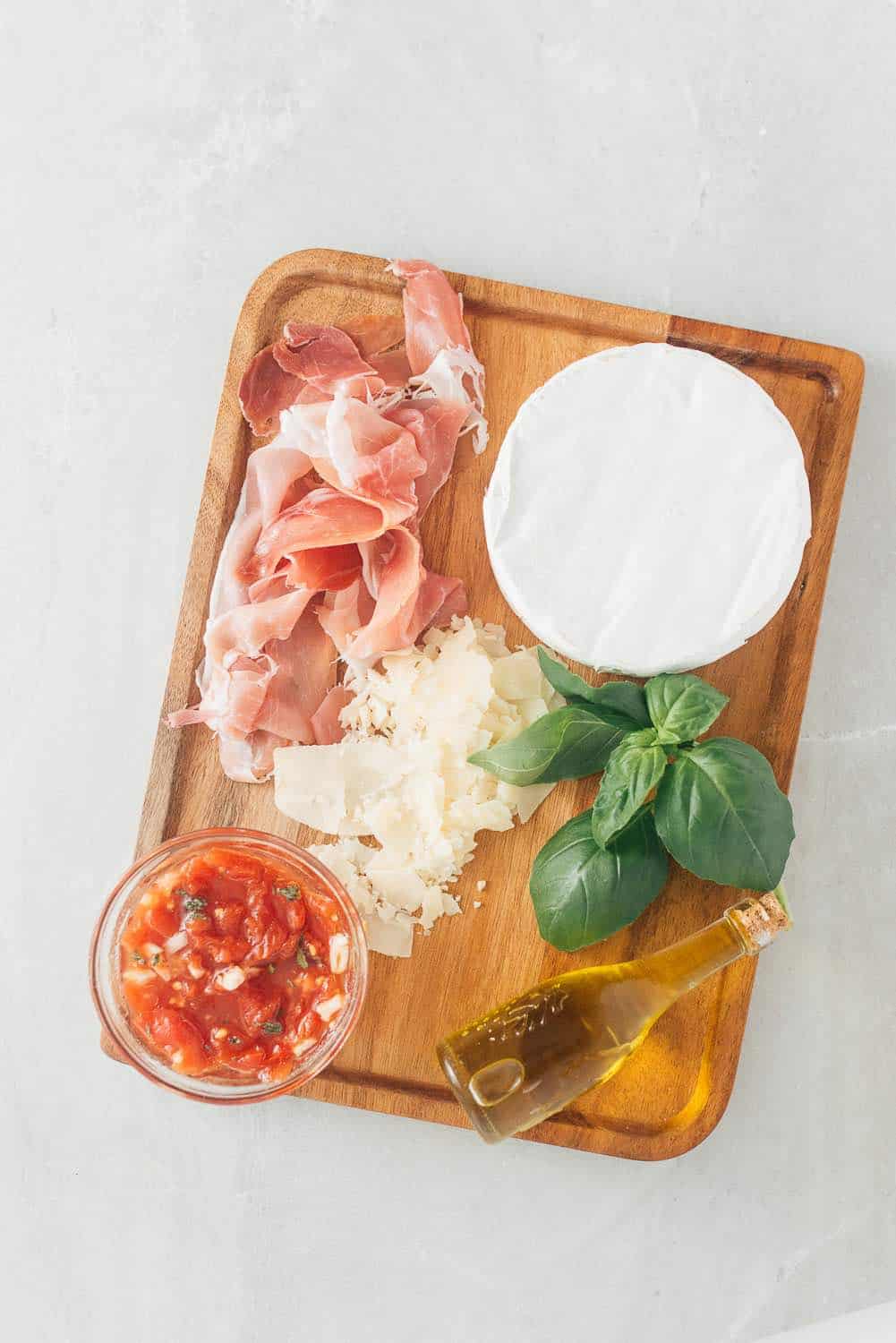 Brie, basil, olive oil, parmesan and proscuitto topping for beer dough pizza. 