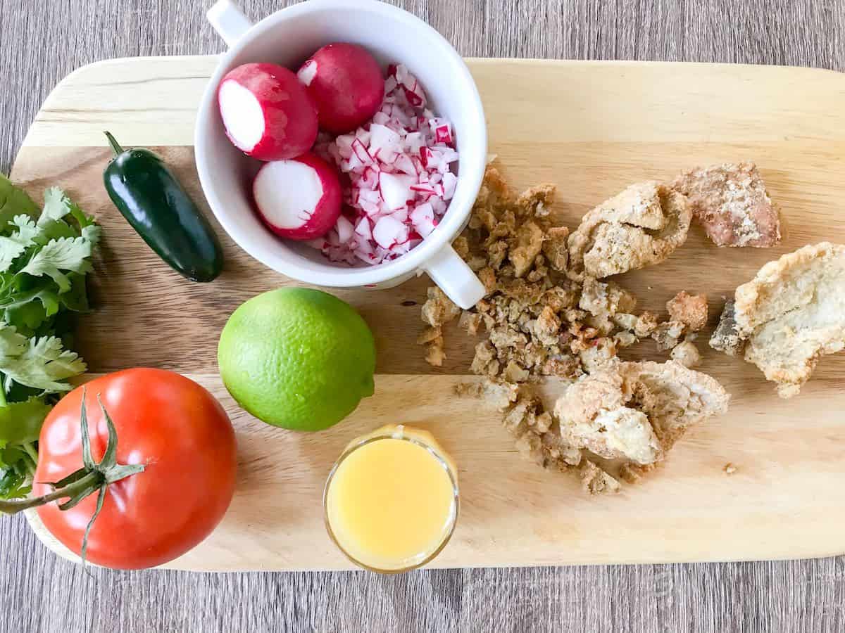 Ingredients for Guatemalan chojín salad including radishes, fresh lime juice, orange juice or naranja agria, white onion, chicharrones, jalapeno pepper, fresh tomato, fresh mint.