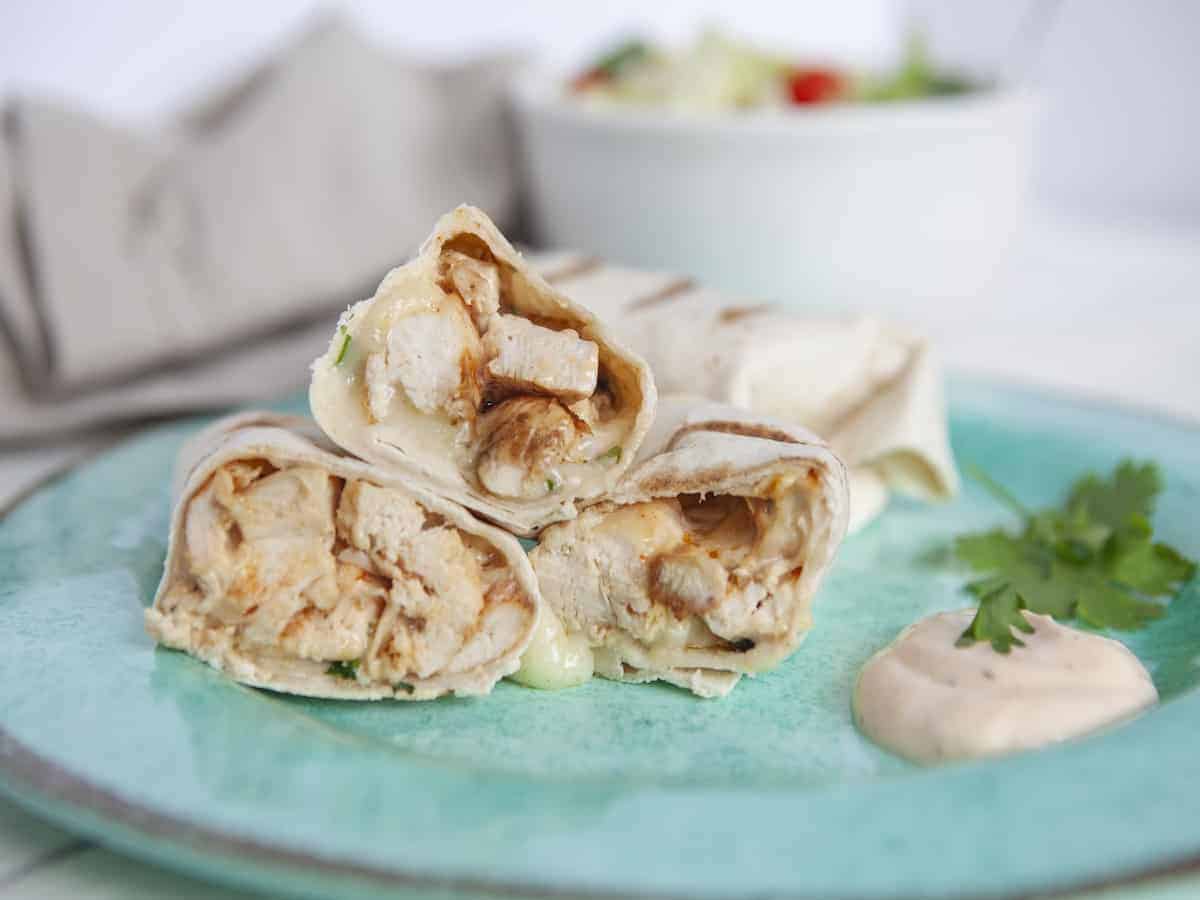 Spicy chicken wrap on a blue plate.