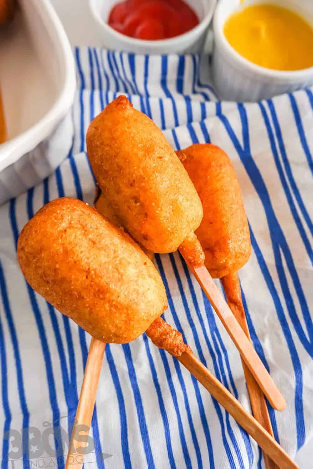 mini corn dogs on a summer napkin.