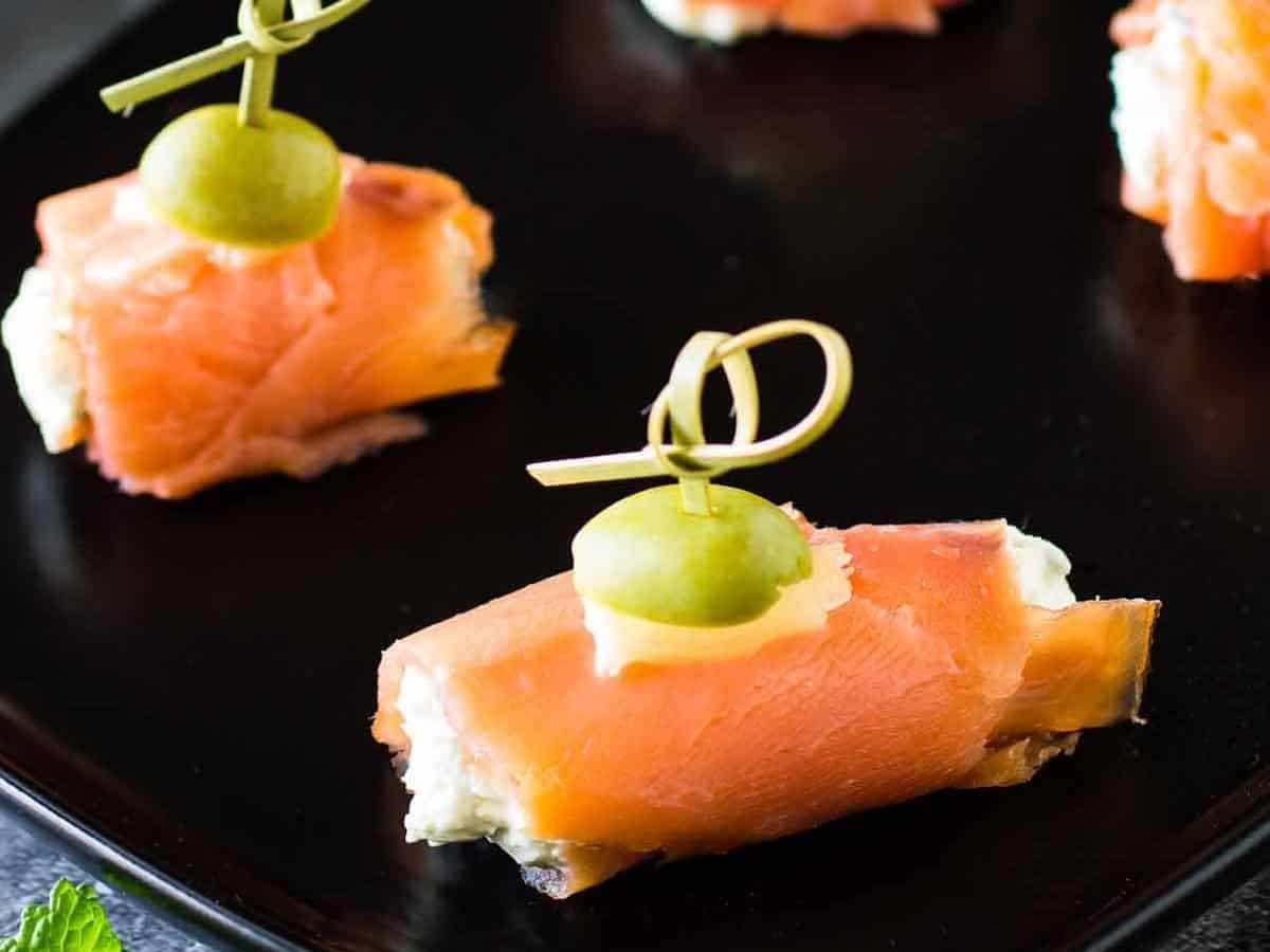 Smoked salmon and cream cheese on a black plate.