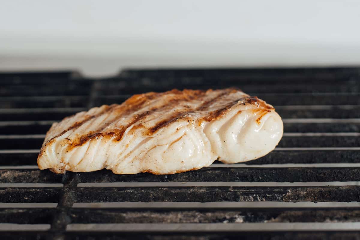 Halibut grilling on a barbecue. b