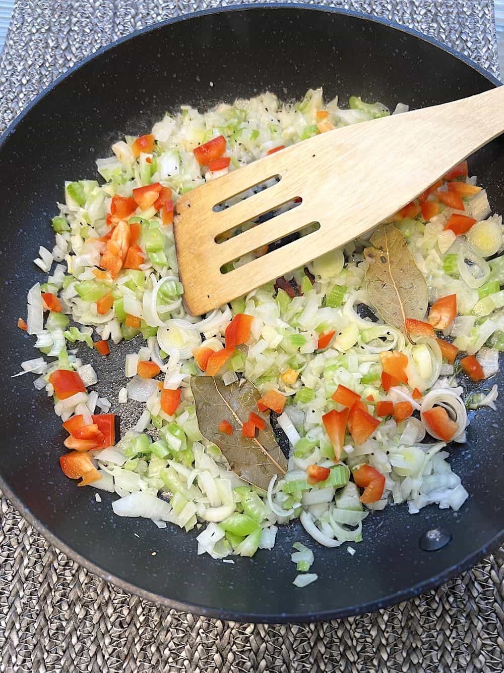 vegetables cooking in a frying pan.