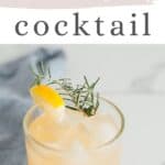 feature pin of camomile whisky cocktail in a glass on a light background next to a blue napkin