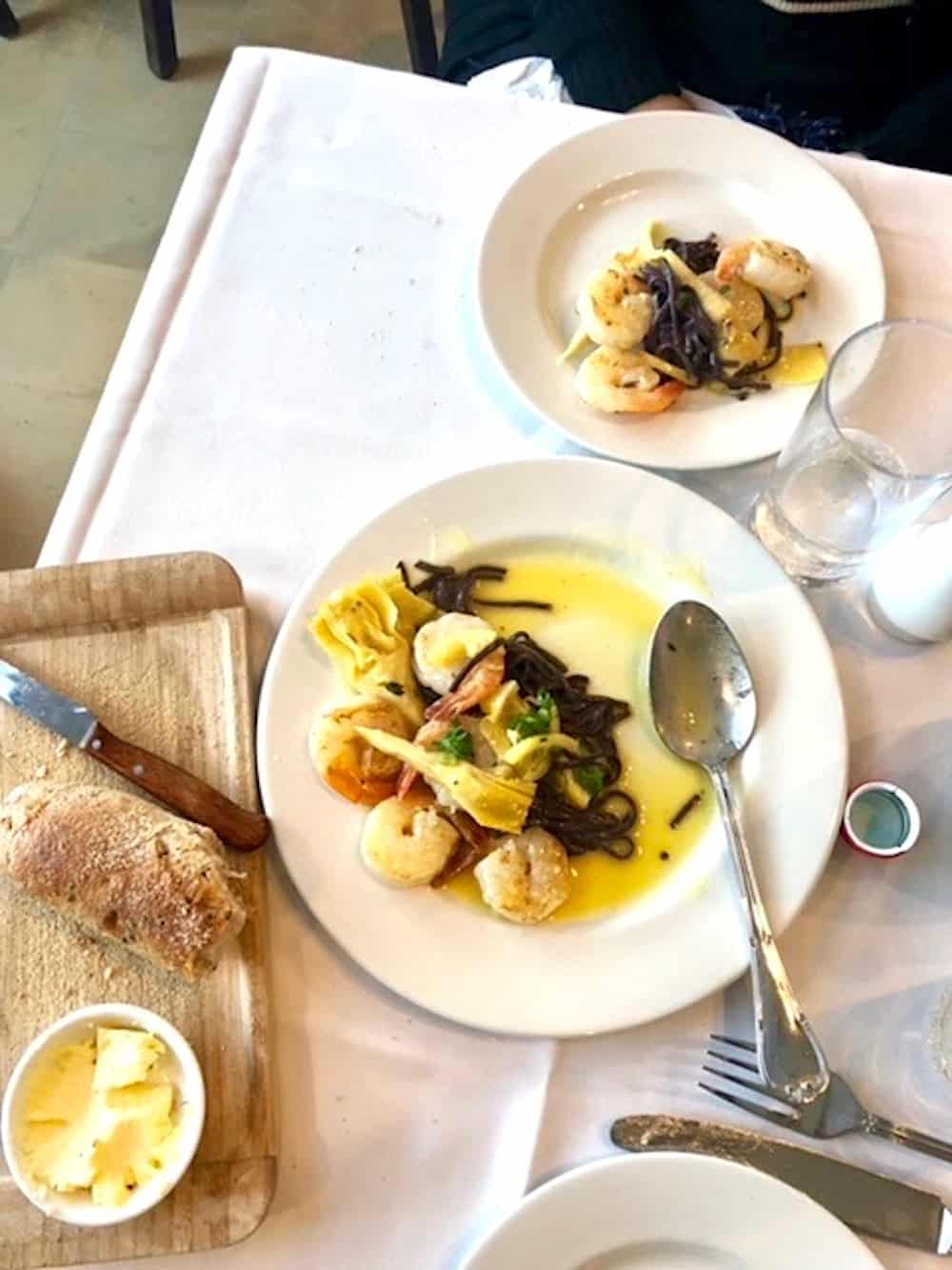 White plates with shrimp and artichokes in lemon sauce at Uri Beri Restaurant.