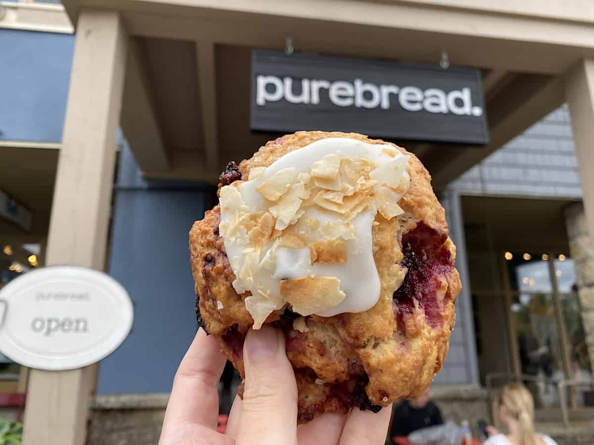 Woman holding a baked treat from Pure Bread in Whistler.