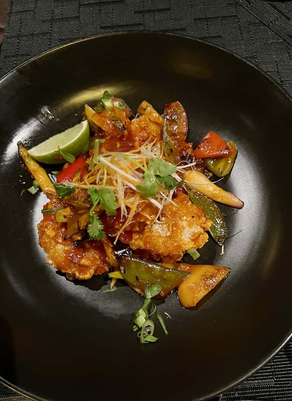 Asian food on a black plate at Tamarind restaurant. 