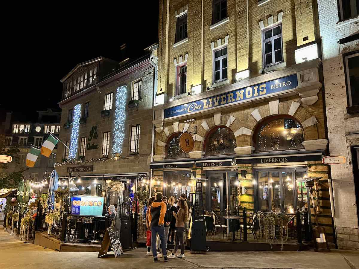 People outside a restaurants in Quebec City at night. 