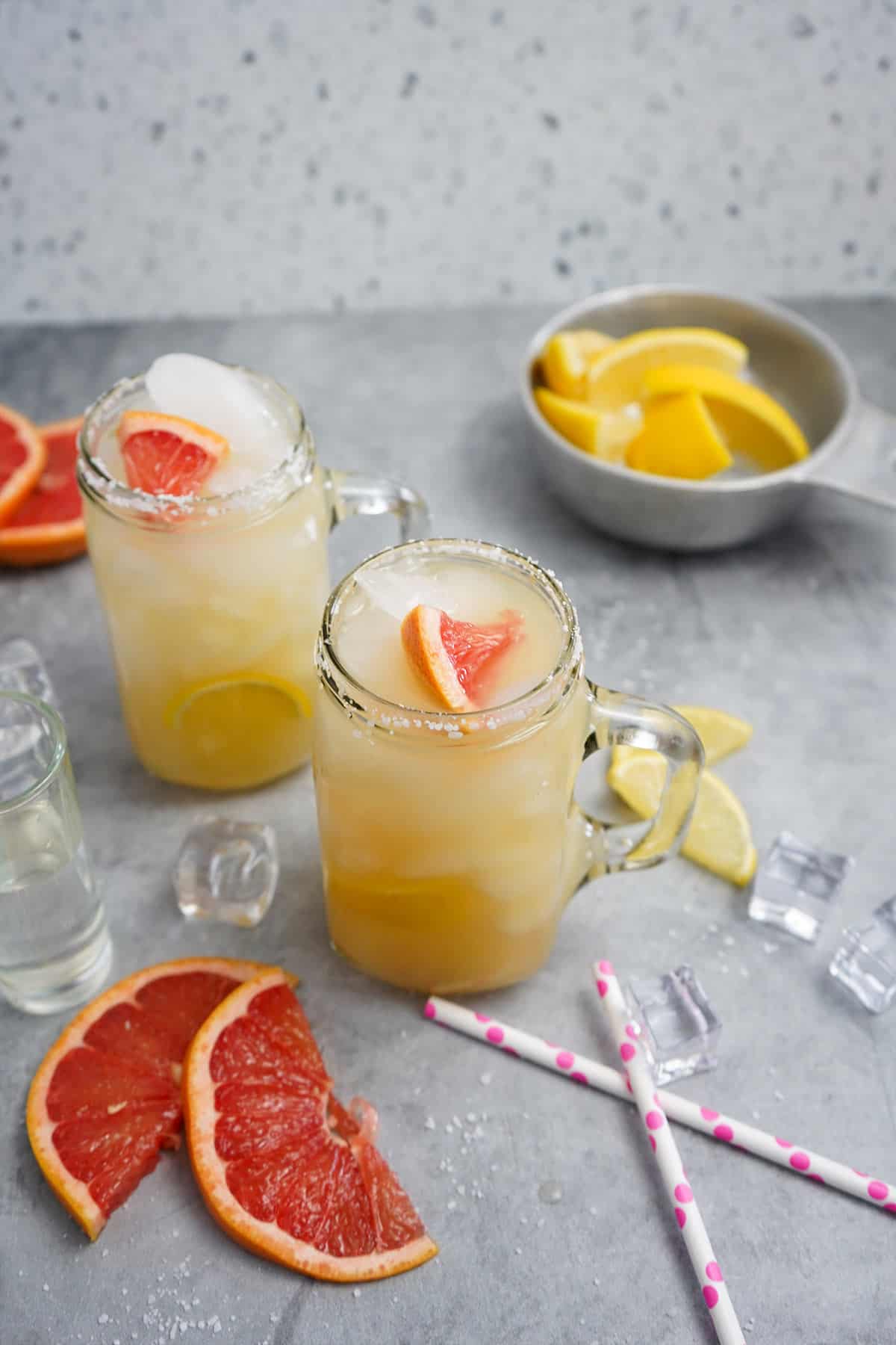 Two grapefruit paloma cocktails with mezcal on a table.