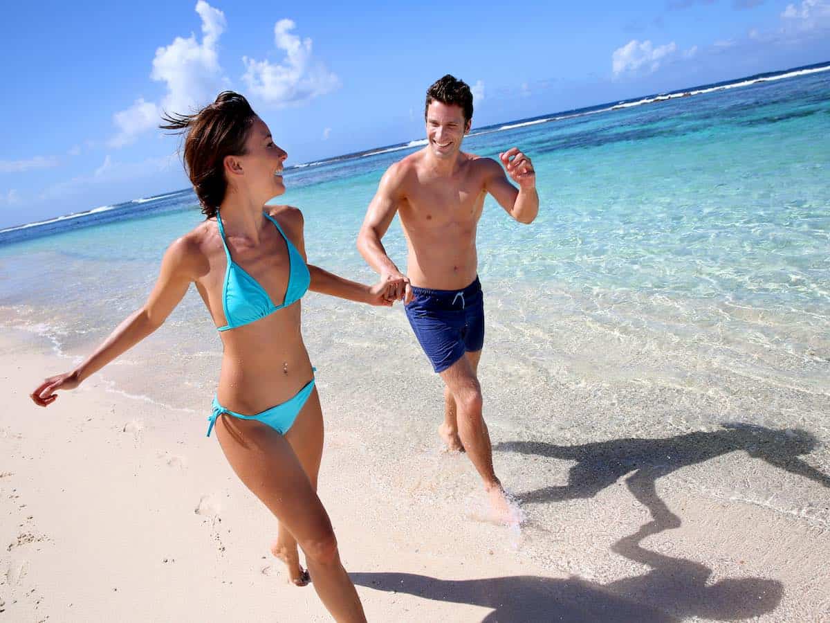 Young couples walking on a sandy beach. 