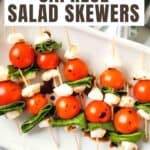 Caprese Salad Skewers on a white plate with Pinterest text overlay.