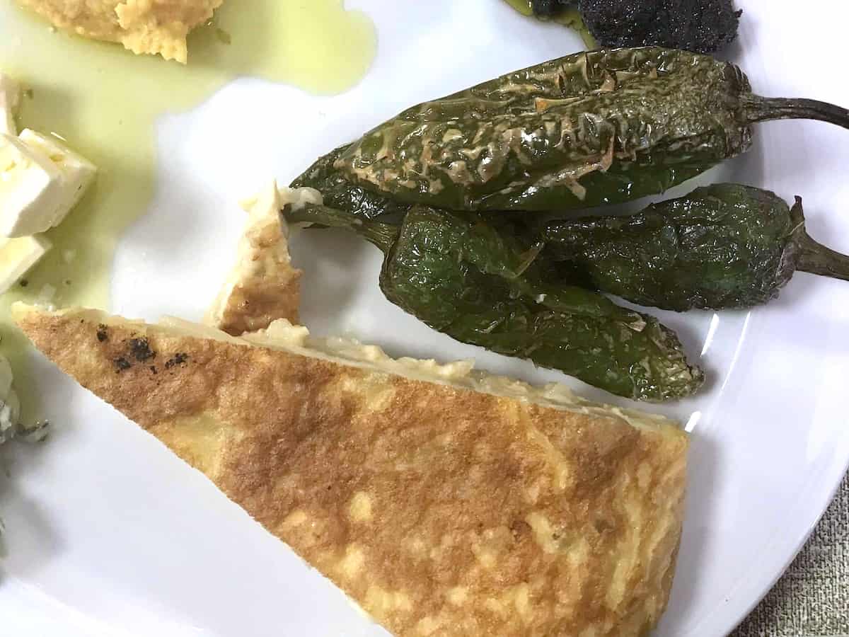 A wedge of Spanish tortilla on a white plate.