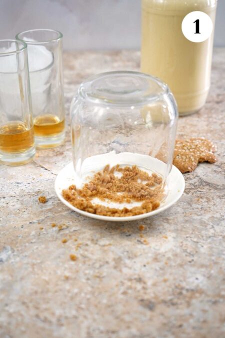 Dipping the glass in crushed gingerbread cookies.