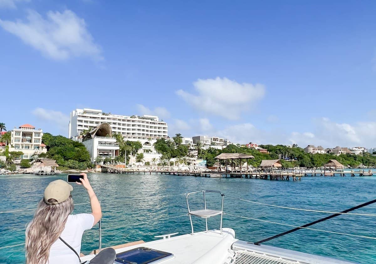 Woman taking a photo on a boat at Impression isla Mujeres. 